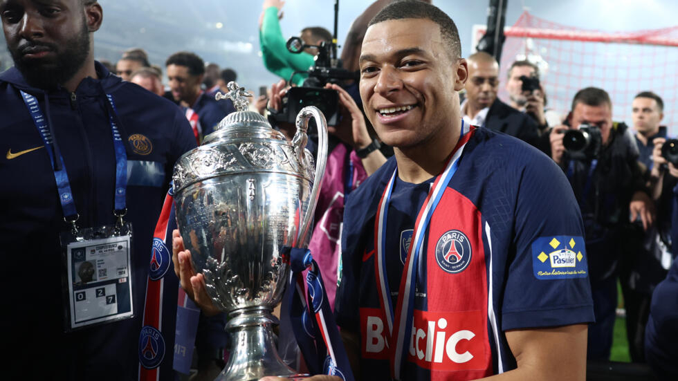 Kylian Mbappe parades the trophy after PSG beat Lyon 2-1 in Saturday's French Cup final.